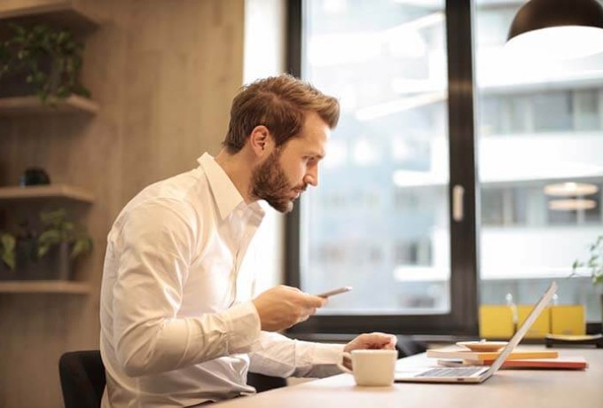 A man is sitting at a laptop